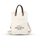 Bolsa matera de tela canvas color beige, con bolsillo frontal, división interna para termo y mate. Incluye correa de galón desmontable y asa de mano removible con broches.