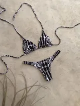 Conjunto de bikini verde esmeralda, con corpiño triangular de atar al cuello y espalda, con almohadillas desmontables, y bombacha colaless con laterales fijos.