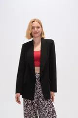 Blazer color beige de lino, con cuello solapa, corte holgado y bolsillos laterales.