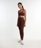 Conjunto deportivo color marrón compuesto por un top de breteles anchos y calzas largas de cintura alta.