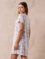 Camisón corto negro con lunares blancos, de tejido suave y escote redondo con detalle plisado y moño blanco.
