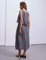 Vestido largo sin mangas de gasa estampada en tonos azules y marrones. Presenta escote redondo y corte en la cintura con punto smock.