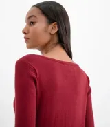 Suéter de punto color verde, con cuello barco, mangas largas y textura acanalada.