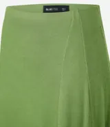 Pollera midi evasé color verde, confeccionada en tejido de punto rib con viscosa certificada, de corte asimétrico y cintura elástica.