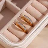 Par de aros tipo argolla dorados con circonitas incrustadas.