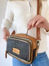 Bandolera de cuero con estampado de cocodrilo en tonos verde, marrón y negro. Tiene correa larga regulable, bolsillo interior y exterior.