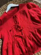 Camisa roja con mangas abullonadas y lazo en el escote.