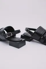 Sandalias bajas color crema con tres tiras en la capellada, una de ellas con textura tipo piel de cocodrilo. Pulsera con hebilla para ajustar al tobillo y taco cuadrado color negro.