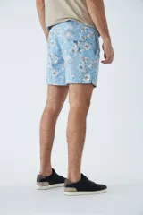 Short de baño azul con estampado de hojas y flores en blanco. Tiene cintura elástica con cordón ajustable, dos bolsillos laterales y uno trasero.