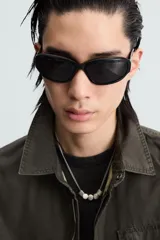 Cazadora color verde oscuro de corte relaxed fit, confeccionada en tejido técnico. Tiene cuello solapa, manga larga con puño abotonado, bolsillos plastrón en el delantero y bajo ajustable con elástico en los laterales. Presenta efecto lavado y cierre frontal con cremallera oculta por solapa con botones a presión.