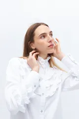 Camisa blanca de algodón con broderie y volados en cuello alto y puños.