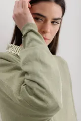 Sweater color crema de viscosa, poliéster, elastano y lurex, de corte holgado y mangas largas.