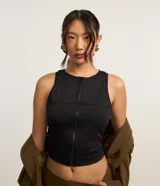 Musculosa negra sin mangas confeccionada en microfibra con cuello redondo y cremallera frontal. Diseño ajustado al cuerpo.