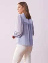 Camisa celeste de gasa, marca Tahari. Cuello con solapa y abertura central con botones ocultos. Manga larga abullonada con puño y botones. Forro de gasa a tono.