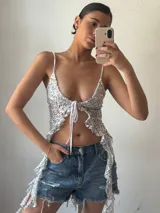 Top plateado con lentejuelas, breteles finos y lazo ajustable en el frente.