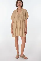 Vestido corto celeste de lino, con cuello tipo polo con detalle de puntilla, mangas cortas y falda escalonada con volantes.