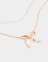 Collar corto doble, con cadena superior de perlas y cadena inferior dorada con dije de moño.