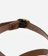 Sandalias planas de cuero color marrón, con múltiples tiras finas ajustables con hebillas doradas. Tira que se ata al tobillo.