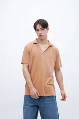 Chomba color ocre, de algodón lavado, con cuello clásico y bordado en el pecho.