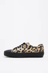 Zapatillas deportivas bajas con estampado animal print, puntera y suela de goma negra y cordones negros.