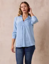 Blusa celeste de lyocell con cuello con solapa, escote en V y abertura con botones. Mangas ¾ con puño y botón.