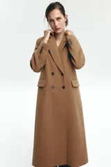 Abrigo largo color camel de Zara Woman Collection, confeccionado en hilatura con lana. Tiene cuello solapa con muescas, manga larga, falsos bolsillos delanteros, forro interior a contraste y cierre frontal con botones.
