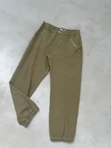 Pantalón color verde militar, de corte recto con elástico en la cintura y tobillos. Tiene bolsillos laterales con cierre de cremallera.