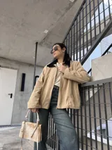 Campera de pana color beige con cierre frontal y cuello negro.