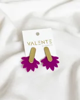 Par de aros colgantes con base de acrílico fucsia en forma de flor y pieza superior rectangular de metal dorado.