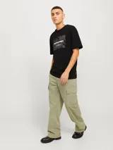 Pantalón cargo color beige, de pierna ancha, tiro medio alto y fit amplio. Cuenta con bolsillos delanteros, traseros y laterales, además de puños ajustables con cordón. Cierre con cremallera.