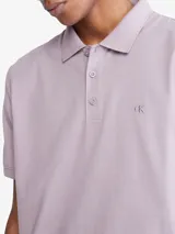 Chomba manga corta color lila con cuello clásico y tapeta de dos botones. Tiene el logo de Calvin Klein bordado en el pecho. Corte regular.