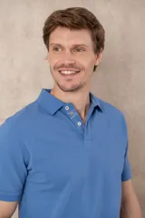 Remera tipo polo color beige, de manga corta y corte clásico. Tiene cuello con botones y está confeccionada en algodón.