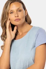 Remera de manga corta y cuello redondo, con bloque de color: cuerpo color crema, manga derecha color rosa y manga izquierda color celeste.