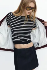 Remera corta de punto fino suave a rayas horizontales azul marino y blancas, con cuello redondo y mangas cortas.