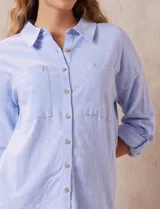 Camisa celeste de lino marca Cable & Gauge, con cuello con solapa, abertura central con botones, bolsillos delanteros, mangas largas regulables con presilla y botón, y largo de espalda mayor al delantero.