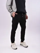Pantalón de jogging negro con bolsillos laterales tipo cargo, corte ajustado y cintura con cordón.