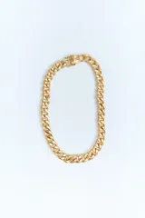 Collar dorado tipo cadena de eslabones metálicos gruesos con cierre de gancho y clip.