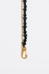 Collar doble, uno con perlitas negras y otro con cadena dorada.