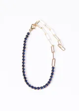 Pulsera dorada con una mitad de eslabones lisos y otra mitad con zirconias azules.