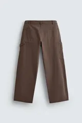 Pantalón negro de corte amplio, confeccionado en tejido de algodón con efecto lavado. Presenta bolsillos frontales, traseros de parche, tira multifunción y bolsillos laterales en las perneras. Cuenta con cierre frontal con cremallera y botón.