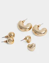 Set de tres pares de aros dorados con diferentes diseños: un par de aros tipo botón, un par con forma de corazón y un par de argollas gruesas.