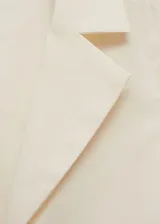 Blusa negra sin mangas con cuello camisero y cierre de lazos en la parte delantera.