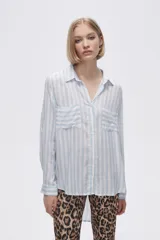 Camisa a rayas verticales grises y blancas, con cuello camisero, cierre frontal con botones, mangas largas con trabillas para enrollar y dos bolsillos de parche en el pecho.