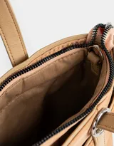 Cartera tipo tote color beige, de tela deportiva, con doble asa corta y correa larga regulable y desmontable. Tiene un bolsillo lateral con forma de pouch.