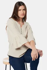 Blusa color beige de lino con botones metálicos personalizados y mangas 3/4 con volados.
