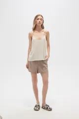 Musculosa color crema de bretel fino con apliques de cadena en los breteles y escote en V.