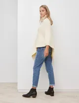 Poncho tejido color negro, con cuello polera y diseño de trenzas diagonales en el frente. Presenta un corte asimétrico en el ruedo.