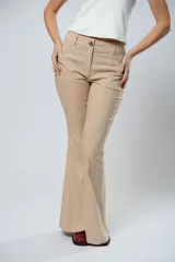 Pantalón de tiro alto color beige, con cierre frontal con cremallera y botón, bolsillos delanteros y traseros, y corte evasé en el bajo.