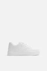 Zapatillas deportivas blancas de estilo retro con suela de plataforma.