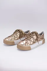 Zapatillas bajas color marrón con textura simil cuero de cocodrilo, cordones al tono y suela de goma blanca con detalle marrón.